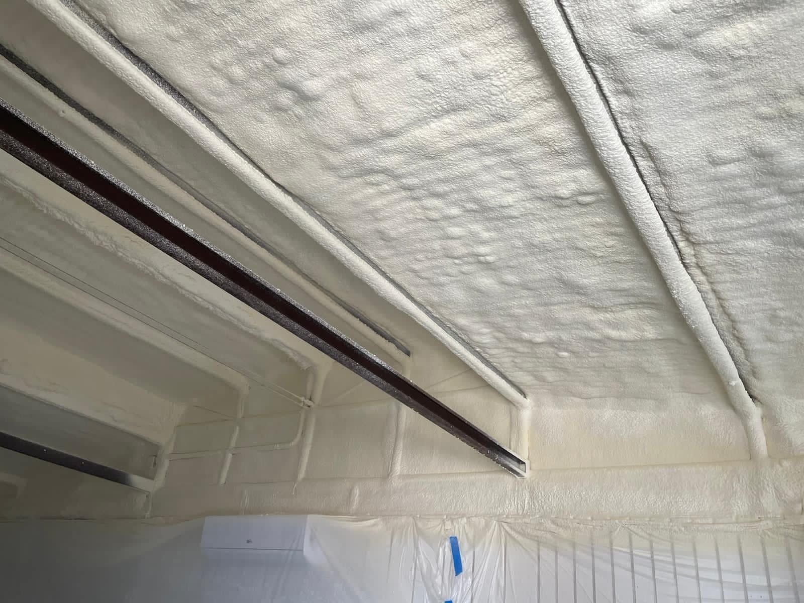 Spray foam insulation crew applying closed-cell foam to a Tucson adobe home at golden hour